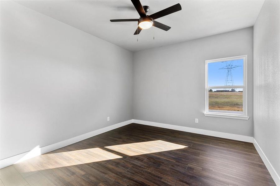 Empty room with dark hardwood / wood-style floors and ceiling fan