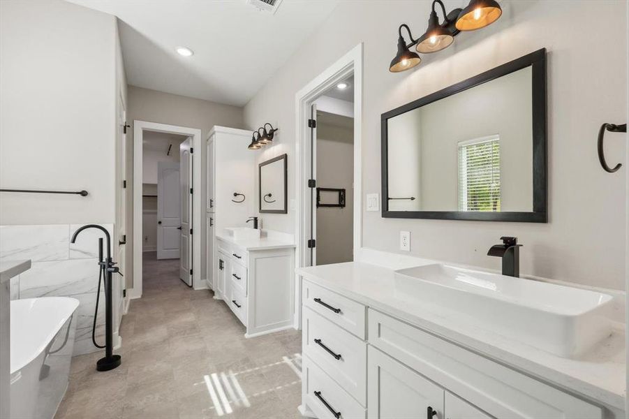 Bathroom with a bathing tub, tile walls, vanity, and tile patterned floors