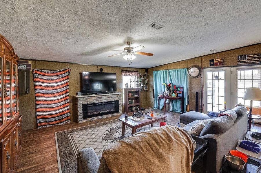 Living room featuring a textured ceiling, dark hardwood / wood-style flooring, and ceiling fan