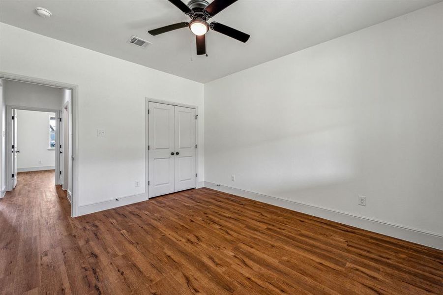 Unfurnished bedroom with ceiling fan, wood-type flooring, and a closet