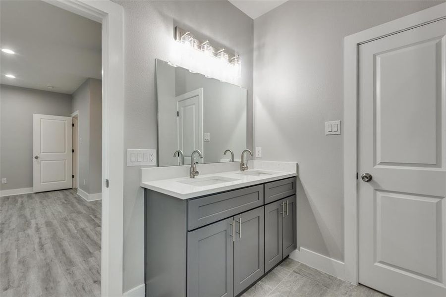 Primary bathroom features dual sinks and walk-in closet.