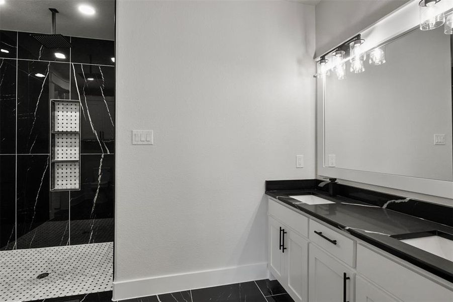 Bathroom with a tile shower, tile patterned flooring, and vanity