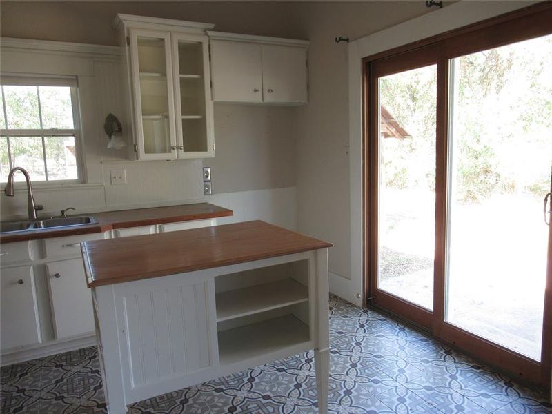 Kitchen with plenty of natural light, sink, and white cabinets