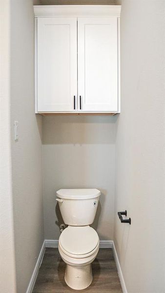 Bathroom featuring hardwood / wood-style flooring and toilet