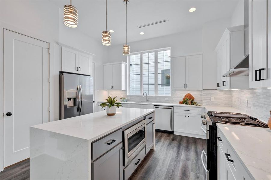 An additional view of the kitchen highlights a microwave seamlessly fitted into the kitchen island, enhancing both functionality and style. Notice the extra storage space in the island, as well!