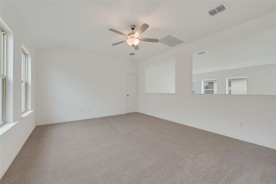 Carpeted empty room featuring ceiling fan