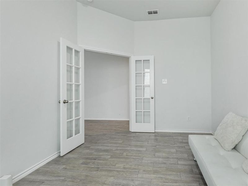 Unfurnished room with french doors and light wood-type flooring
