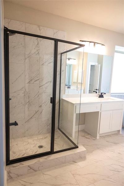 Bathroom with tile patterned floors, a shower with door, and vanity