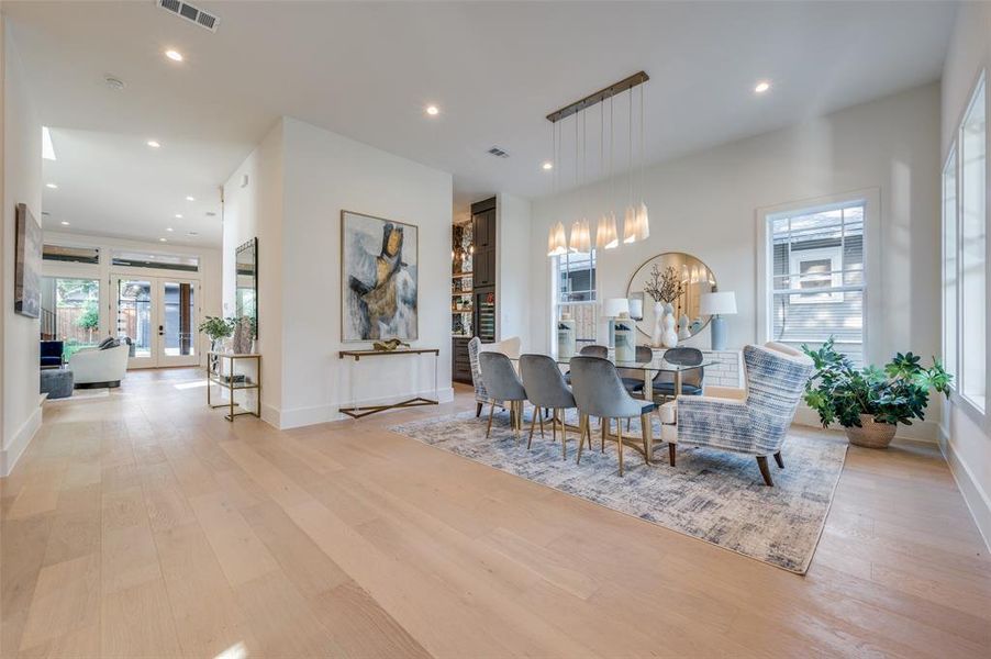 Dining space featuring french doors, a notable chandelier, and light wood-type flooring