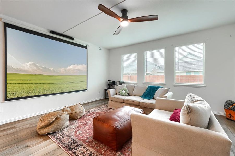 Living room with plenty of natural light, wood-type flooring, and ceiling fan