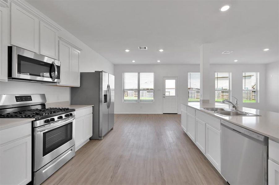 This kitchen is awesome!  Stainless steel appliances, gas range, side-by-side refrigerator, quartz counters and open to the family room