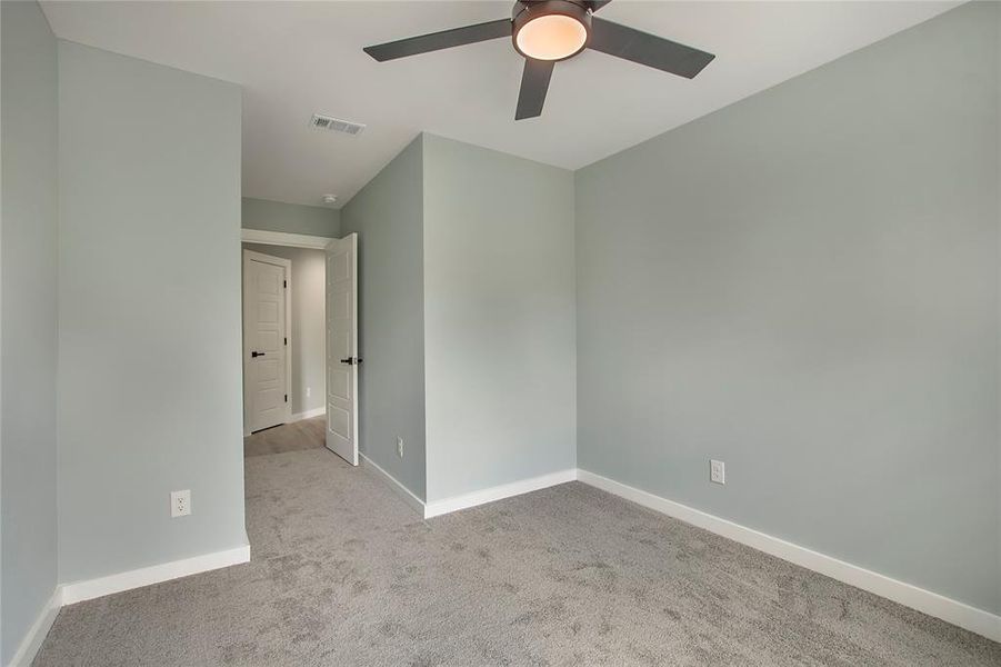 Carpeted empty room with ceiling fan