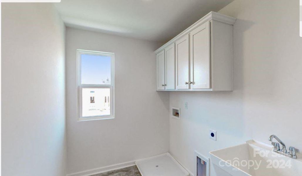 Laundry room with cabinets and laundry sink.