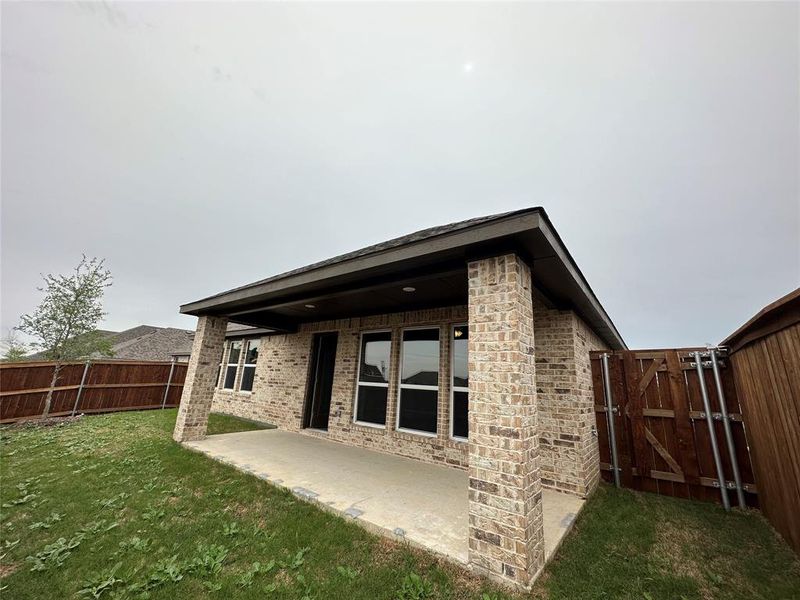 Rear view of house with a yard and a patio