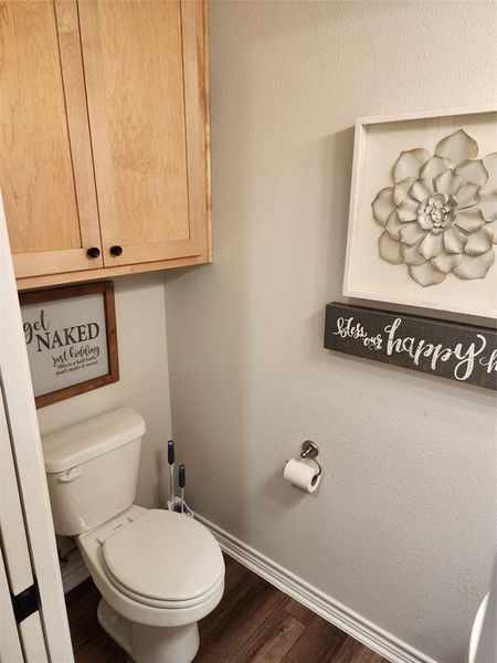 Bathroom with hardwood / wood-style flooring and toilet