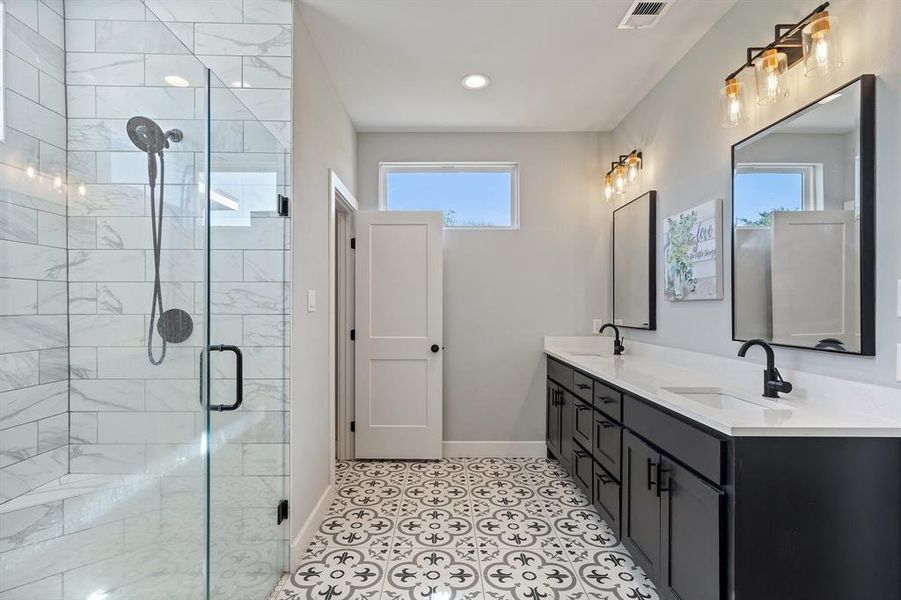 Bathroom with walk in shower, vanity, and tile patterned floors