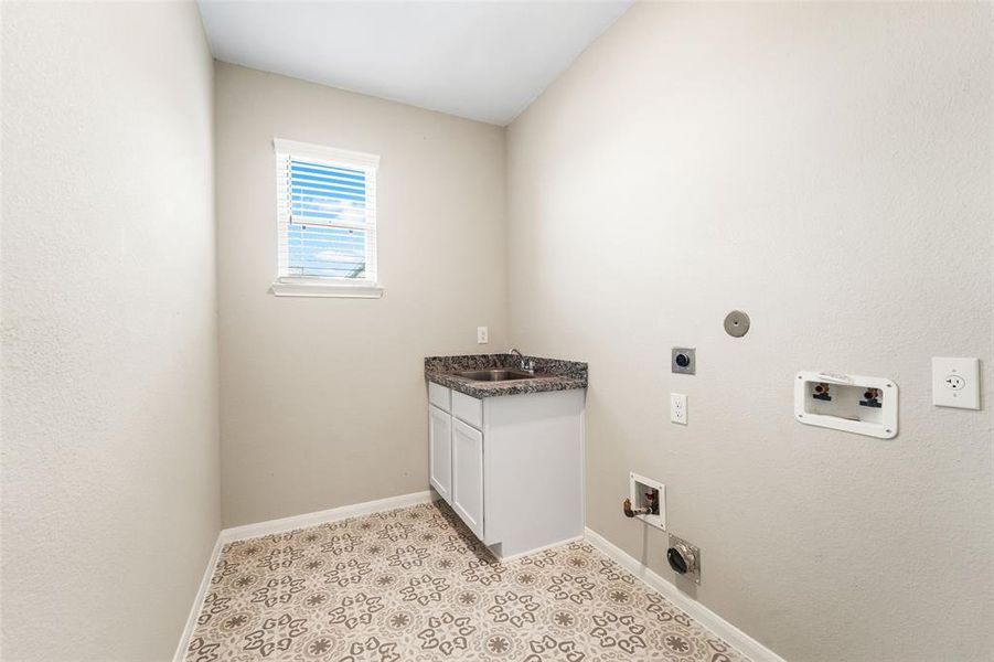 Large laundry room with utility sink, both gas & electric dryer hook ups and room for a 2nd backup fridge