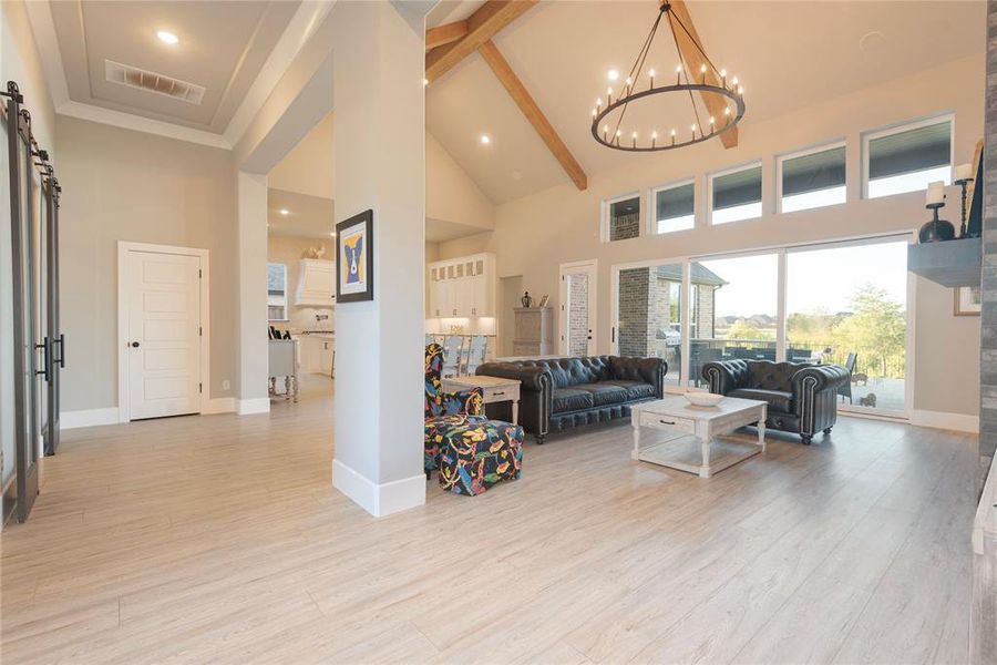 Living room view from front entry area with tall ceilings and crowned molding.