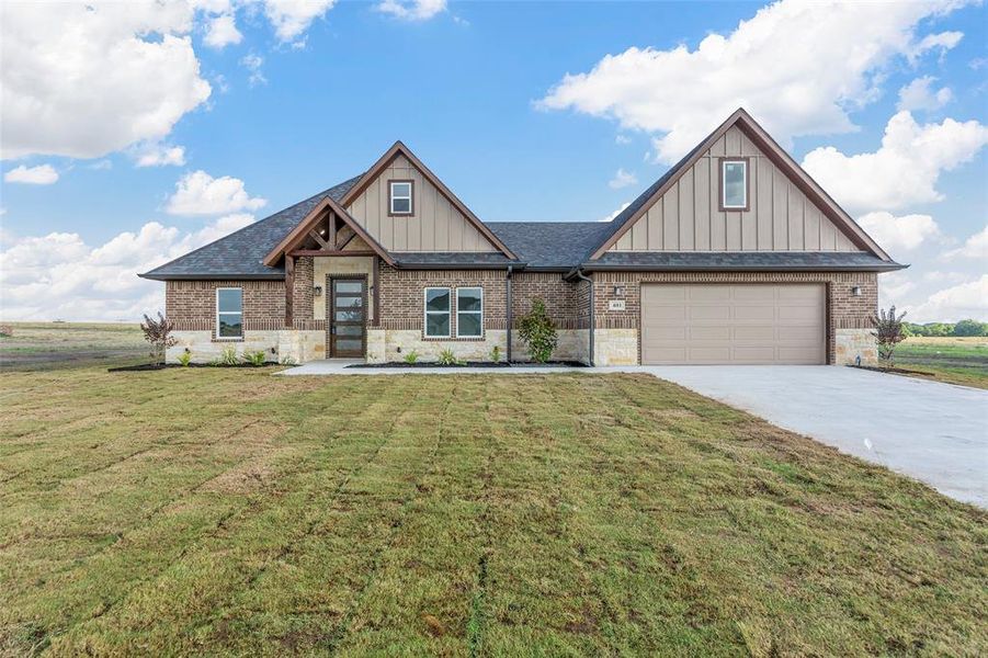 Craftsman inspired home with a garage and a front yard