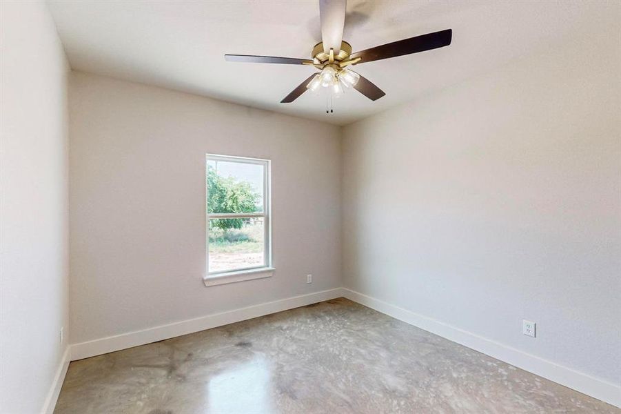 Spare room with concrete floors and ceiling fan