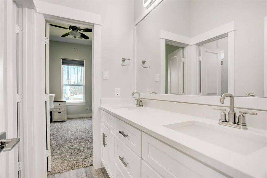 STREAMLINE YOUR MORNING ROUTINE IN THIS SLEEK AND FUNCTIONAL BATHROOM, DESIGNED WITH A MODERN AESTHETIC FEATURING A SPACIOUS DUAL-SINK VANITY AND A LARGE MIRROR.