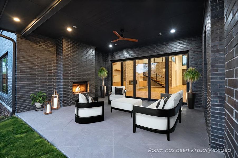 View of patio featuring an outdoor living space with a fireplace and ceiling fan