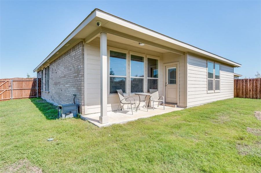 Rear view of house featuring a patio and a yard