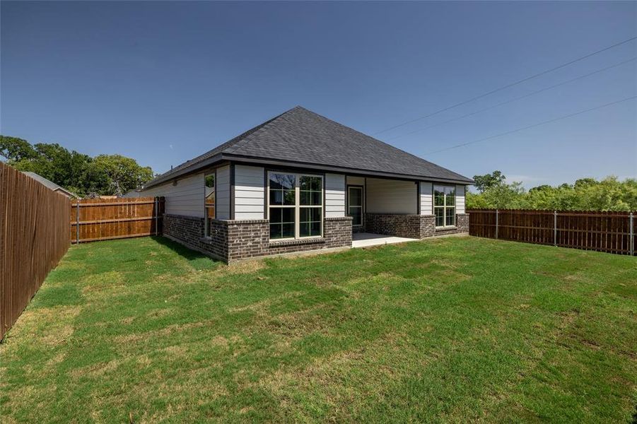 Rear view of house with a patio and a lawn