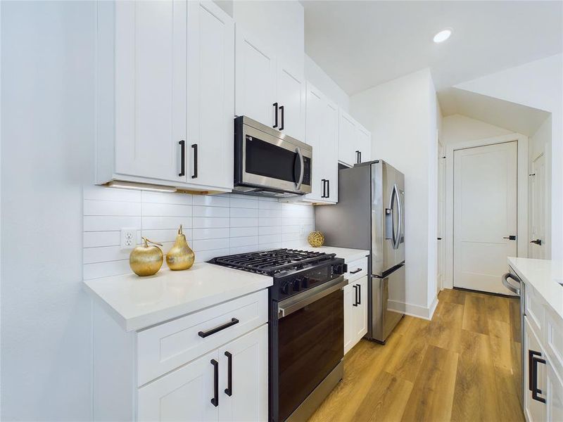 Another angle of the kitchen with garage door in the background