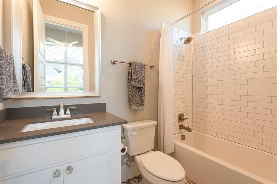 Full bathroom with a healthy amount of sunlight, shower / tub combo with curtain, vanity, and toilet