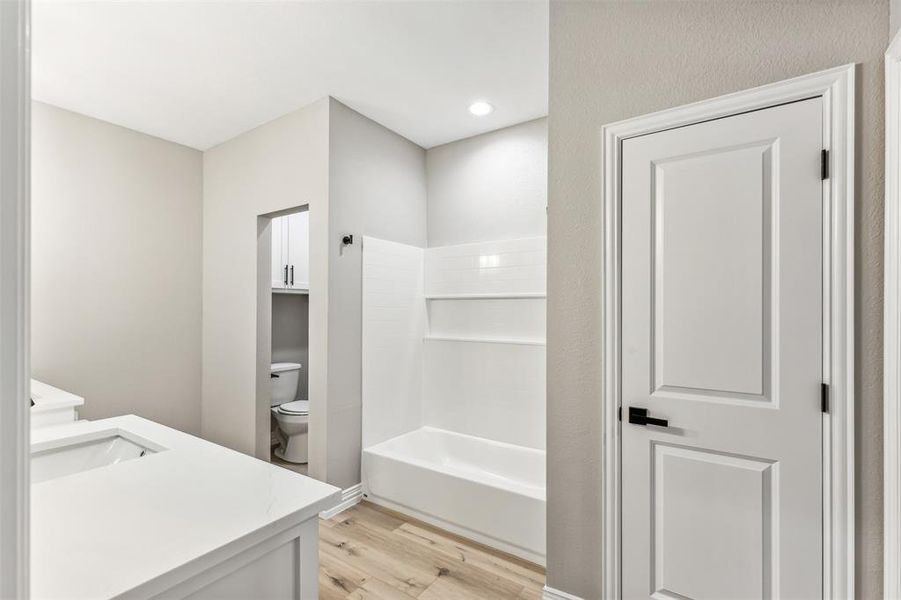 Bathroom featuring vanity, toilet, and hardwood / wood-style floors