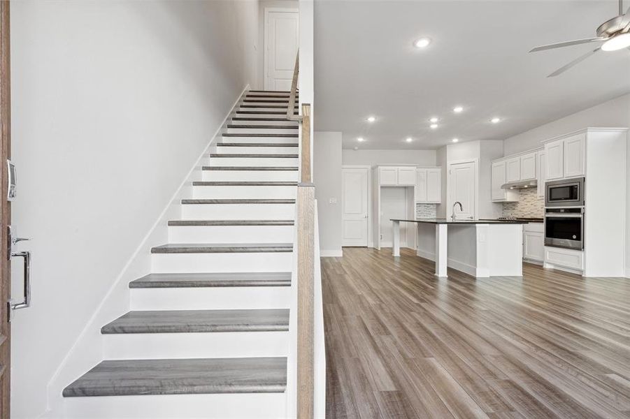 Stairs featuring sink, hardwood / wood-style flooring, and ceiling fan