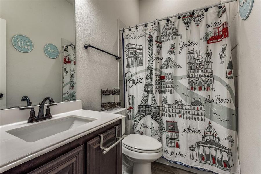 Bathroom with hardwood / wood-style floors, walk in shower, vanity, and toilet