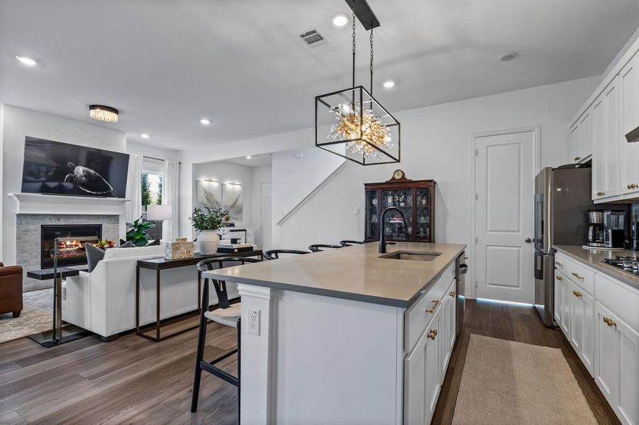 Kitchen featuring a center island with sink, sink, dark hardwood / wood-style floors, and white cabinets