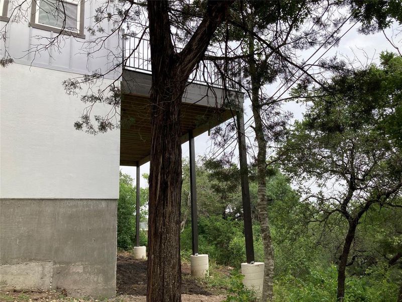 A view of the side of the home which shows the upper level balcony.