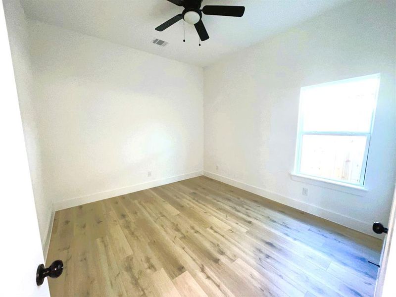 Empty room with ceiling fan and light hardwood / wood-style flooring