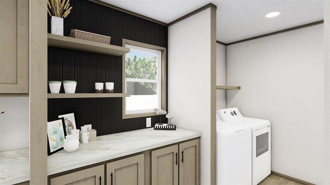Washroom featuring washing machine and clothes dryer, a textured ceiling, cabinets, and ornamental molding