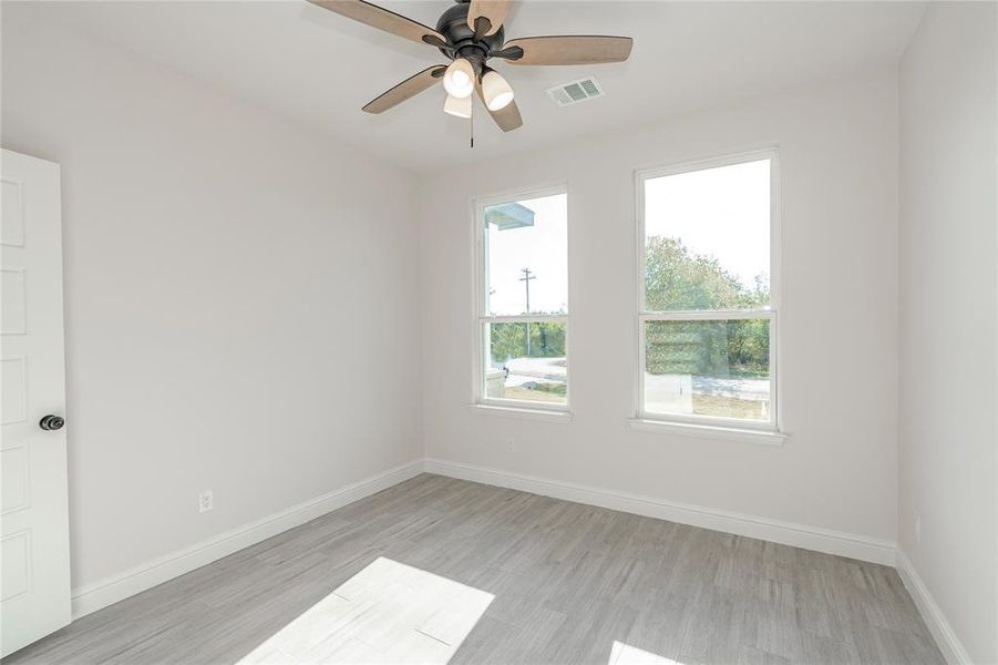 Unfurnished room with light hardwood / wood-style floors and ceiling fan