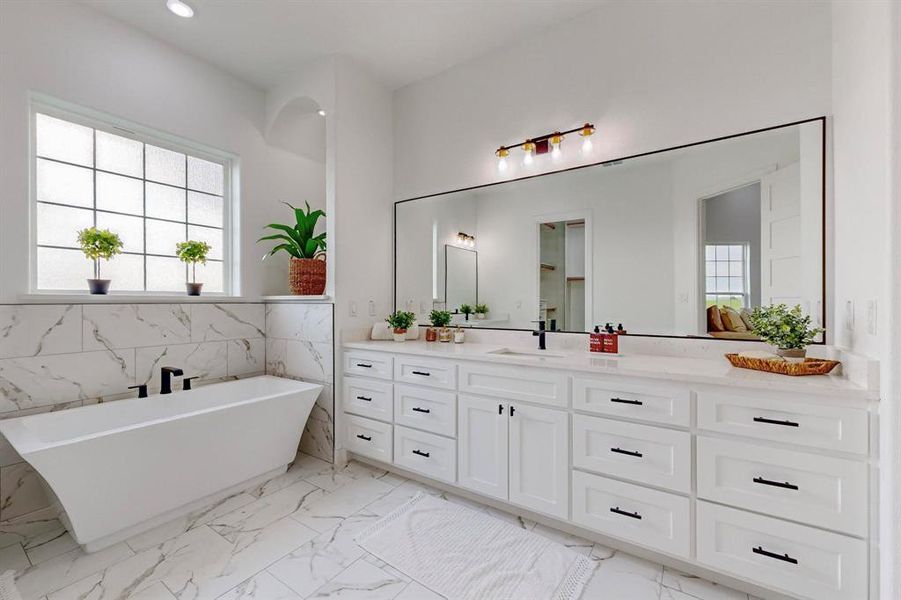 Main Bathroom with tile walls, tile patterned floors, a bath, and vanity