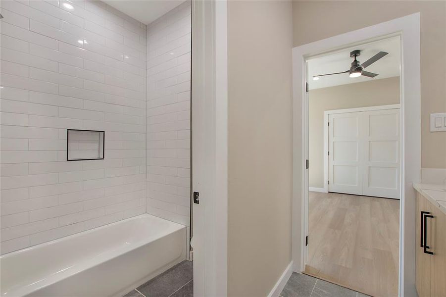 Bathroom featuring tiled shower / bath, vanity, ceiling fan, and hardwood / wood-style flooring