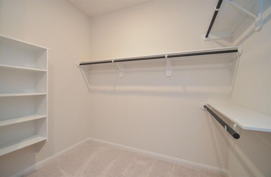 Enjoy plenty of storage with this spacious walk-in closet. Featuring built-in shelving and hanging racks, this well-organized space is ideal for all your wardrobe needs, keeping everything neatly arranged and easily accessible.