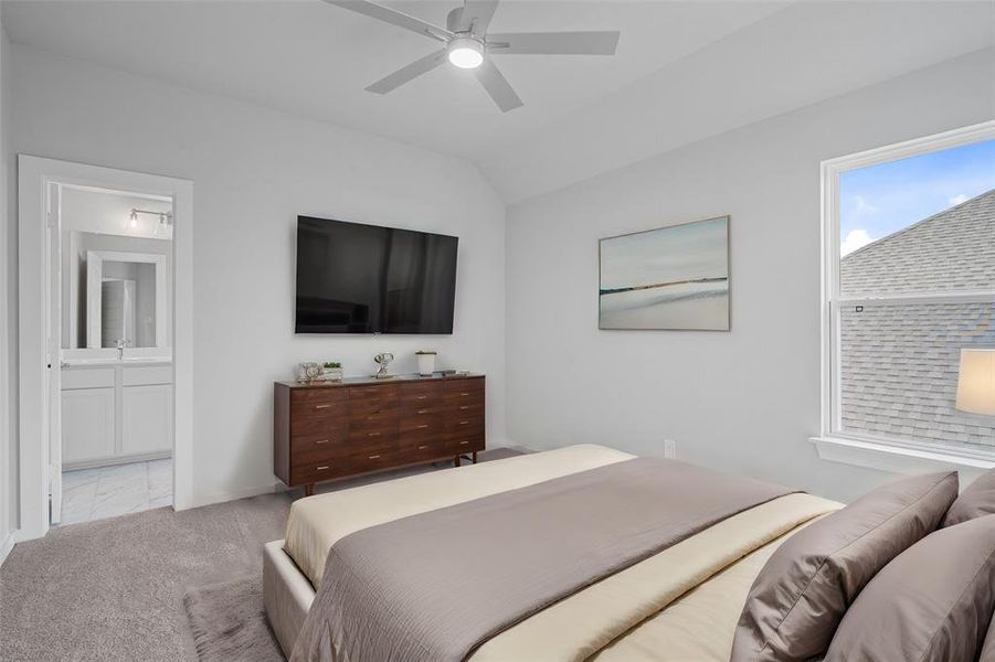 Secondary bedroom features plush carpet, custom paint, dark stained ceiling fan with lighting, large window with privacy blinds, and access to the Jack and Jill bath.