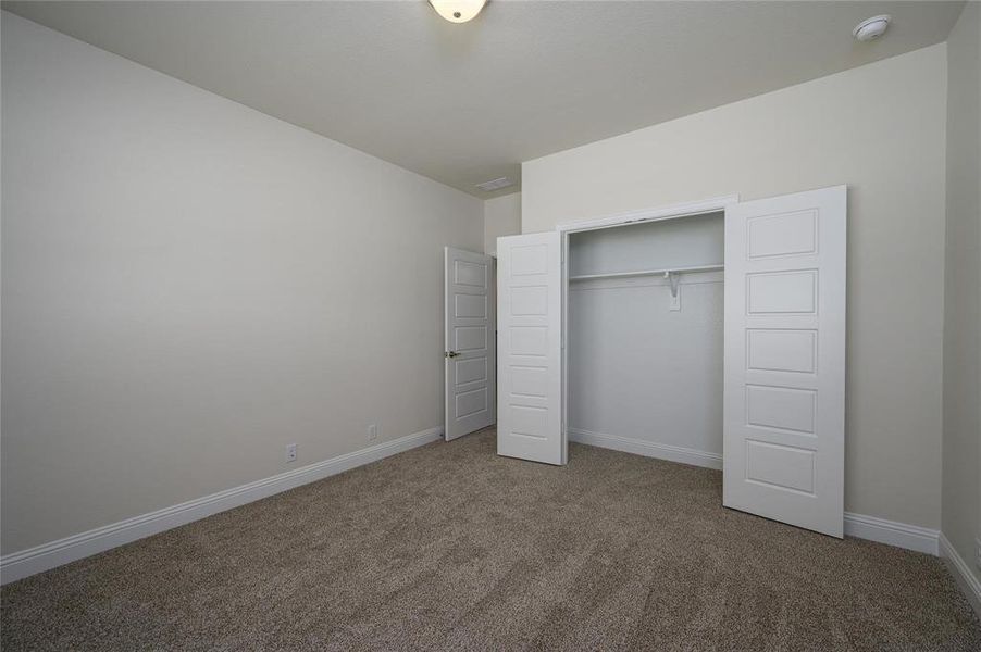 Unfurnished bedroom featuring carpet floors and a closet