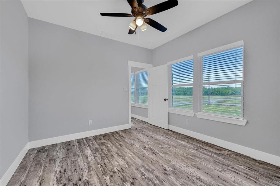 Unfurnished room with ceiling fan and hardwood / wood-style flooring