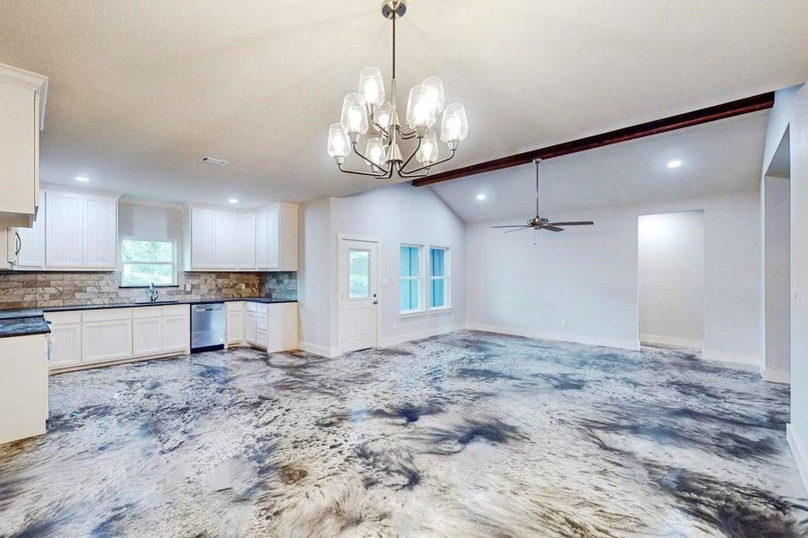 Kitchen featuring backsplash, a wealth of natural light, dishwasher, and lofted ceiling with beams