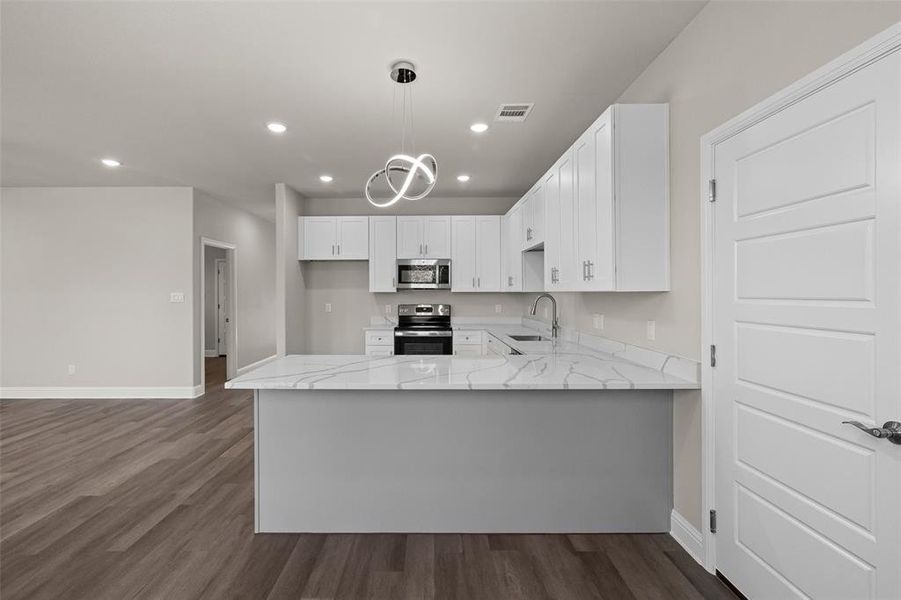 Kitchen featuring hanging light fixtures, sink, dark hardwood / wood-style flooring, and stainless steel appliances