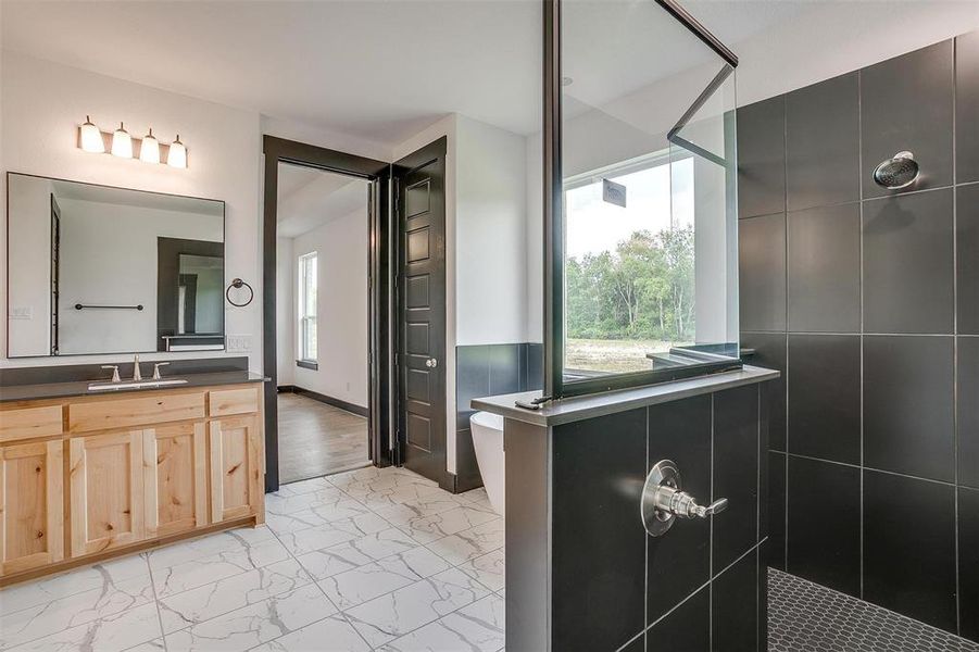 Bathroom featuring a tile shower, tile flooring, and oversized vanity