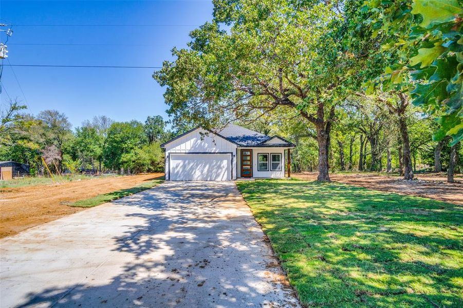 View of front of property with a front yard and a garage