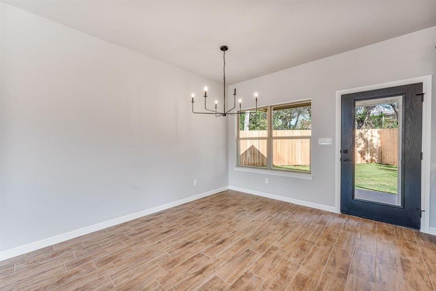 Unfurnished dining area featuring a notable chandelier and light wood-type flooring