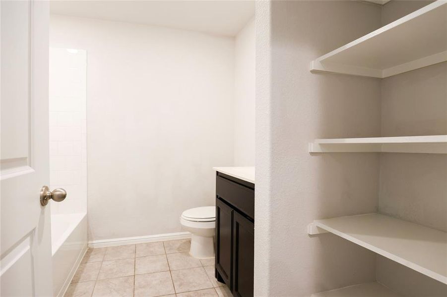 Full bathroom featuring shower / bathing tub combination, vanity, toilet, and tile floors
